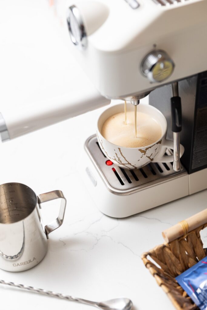 Espresso machine brewing coffee into cup