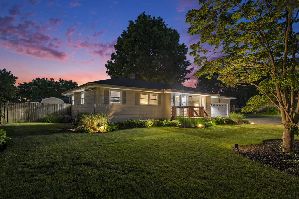 Single-story house at sunset with landscaped yard