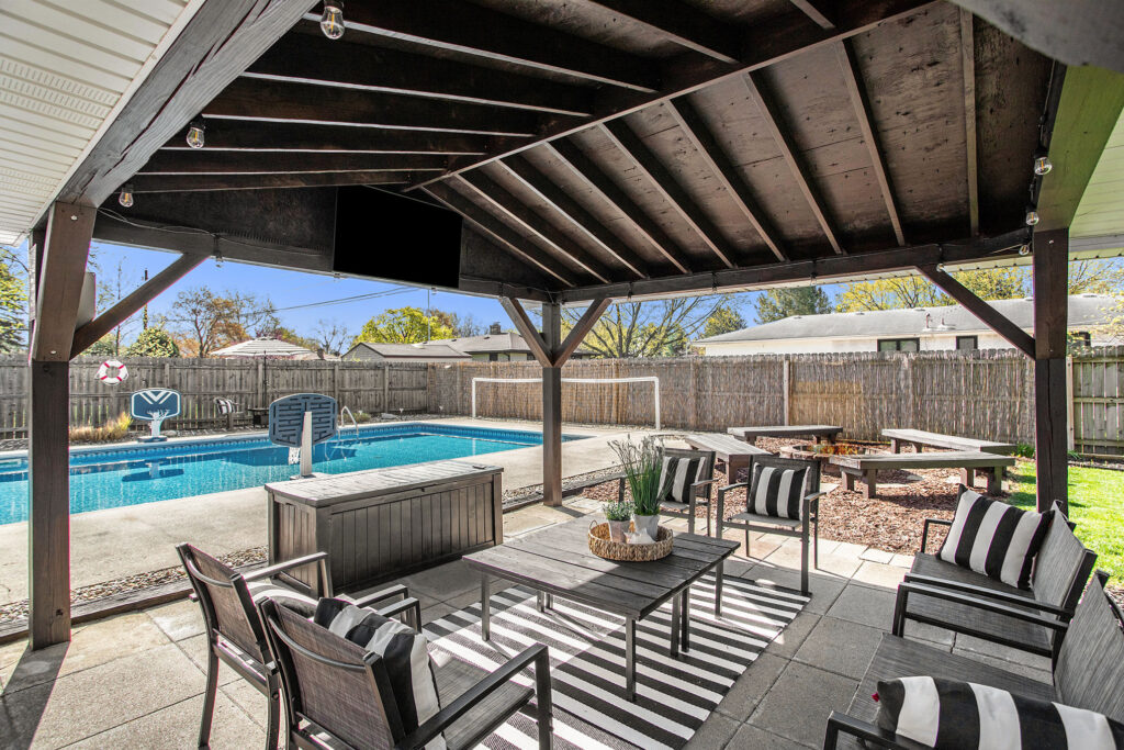 Covered patio seating overlooking backyard pool