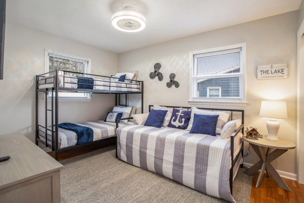 Coastal-themed bedroom with bunk and day beds