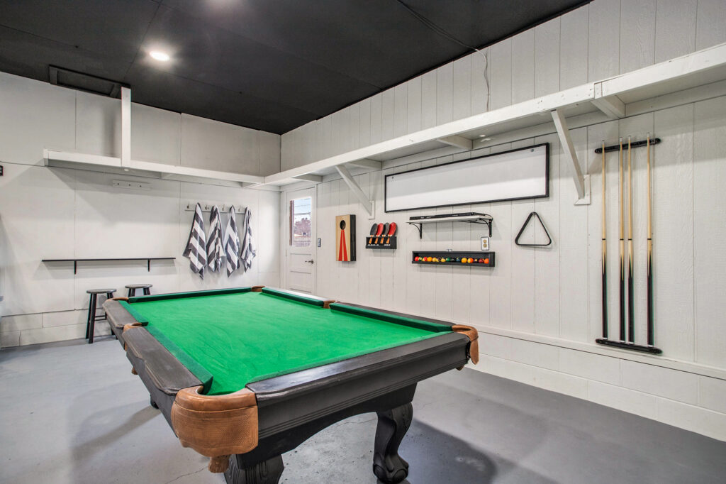 Modern game room with pool table and cues