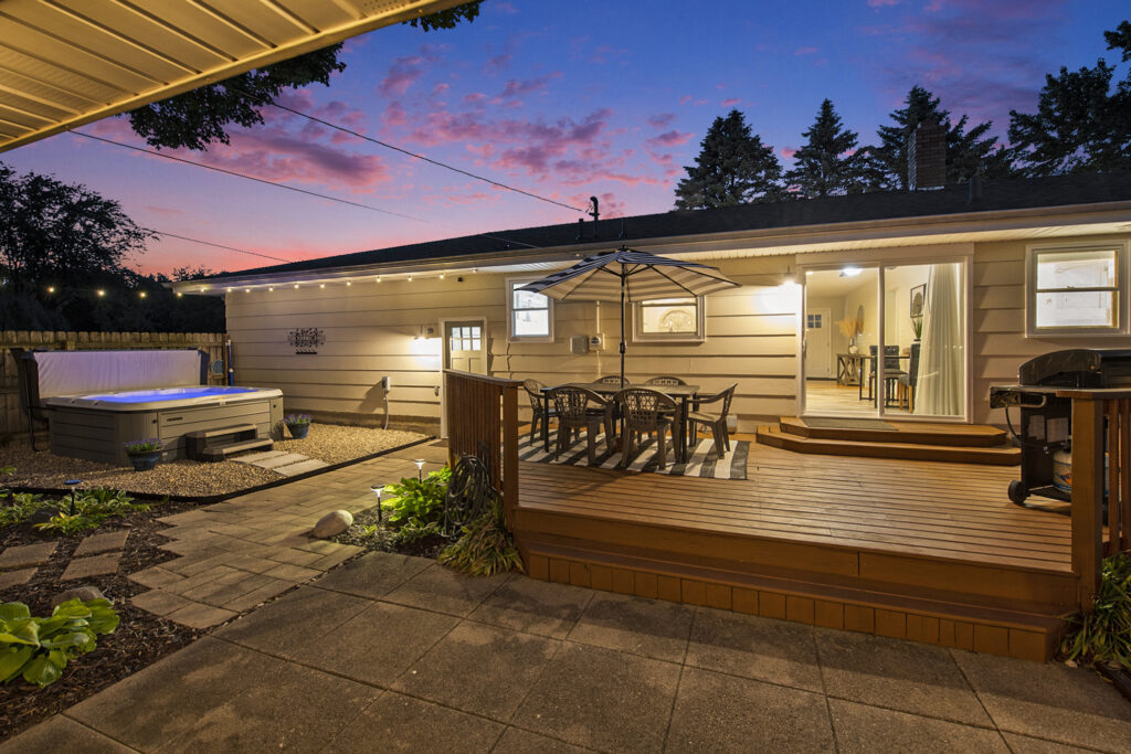 Backyard patio with hot tub at sunset