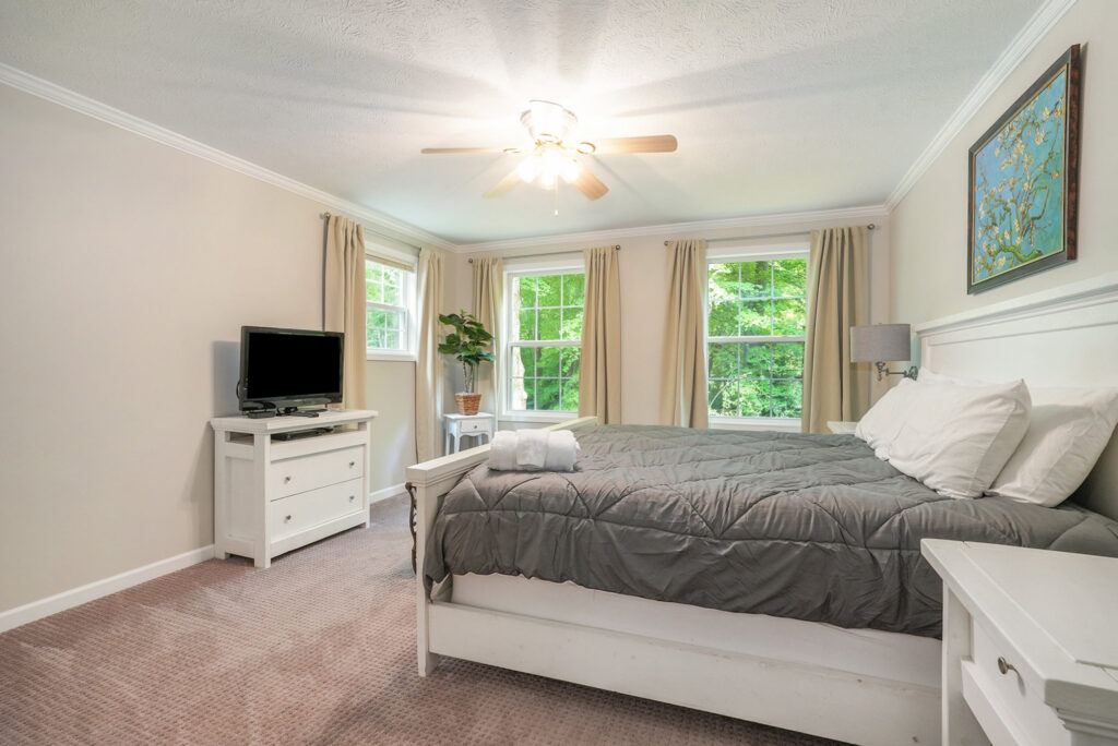 Bright bedroom with gray bedding and white furniture