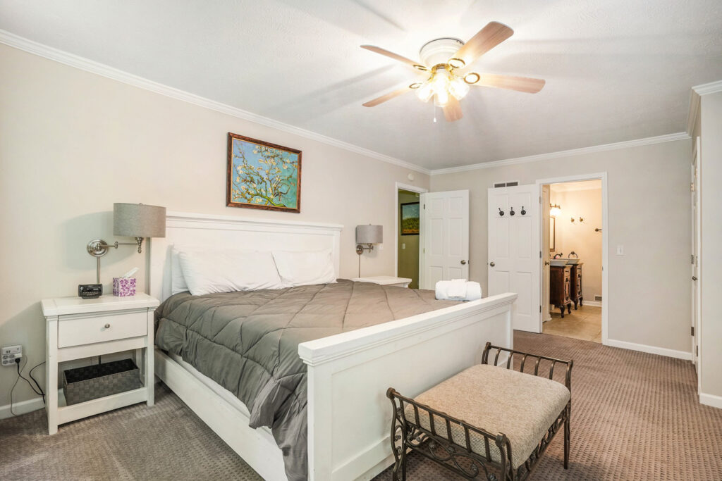 Cozy bedroom with bed and open bathroom door