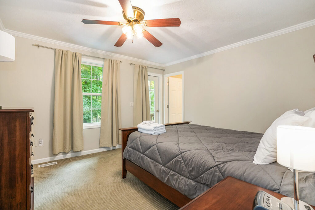 Cozy bedroom with gray bedding and ceiling fan