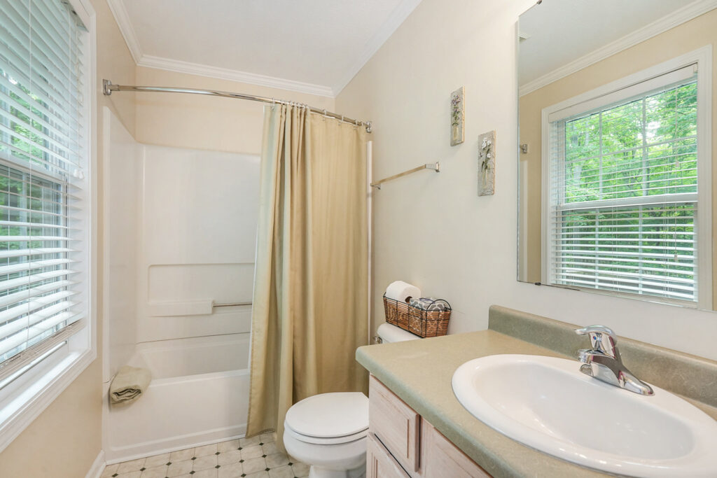 Bright bathroom with shower and beige curtain