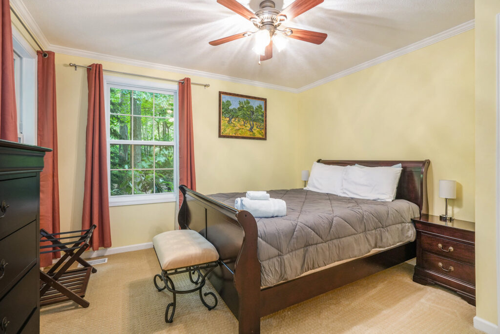 Cozy bedroom with queen bed and ceiling fan
