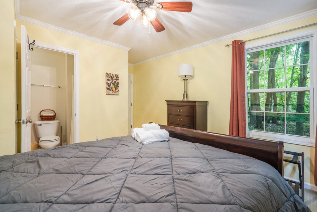 Cozy bedroom with large window and forest view