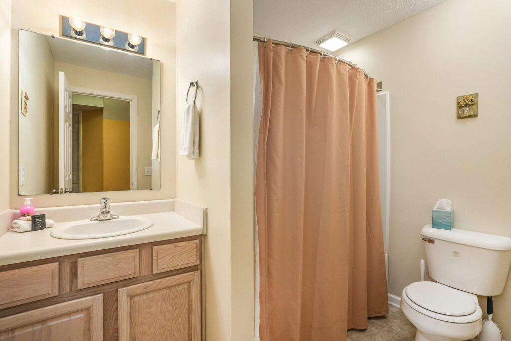 Bathroom with sink, toilet, and shower curtain