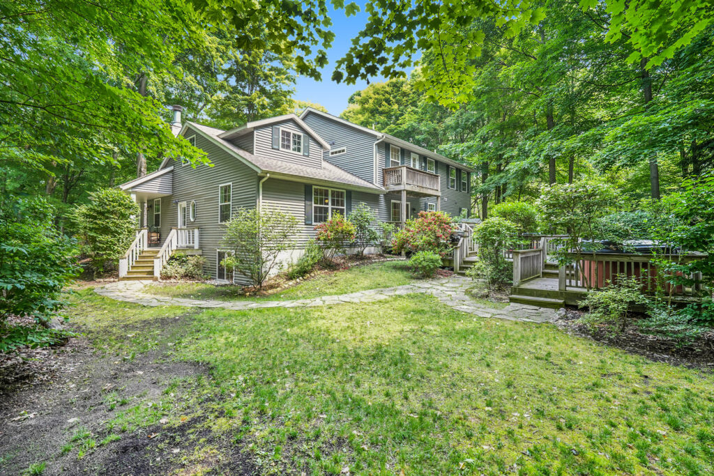 Two-story house surrounded by lush green trees