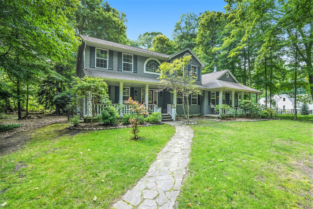 Two-story gray house with front porch and garden