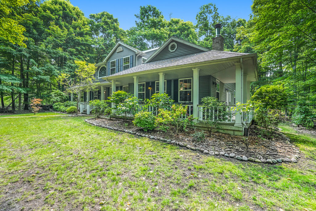 Gray house with porch surrounded by trees