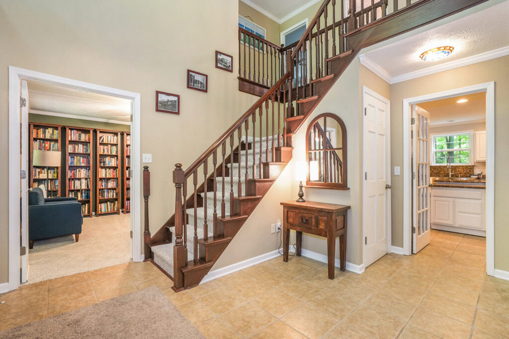 Home entryway with staircase and view to kitchen