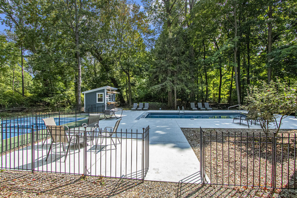 Outdoor pool area surrounded by forest trees