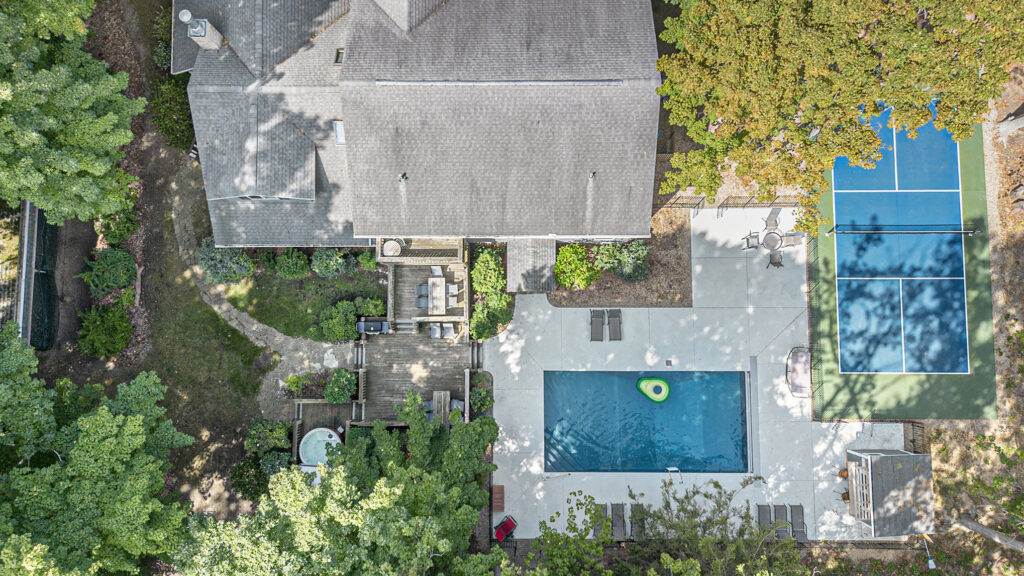 Aerial view of backyard with pool and tennis court