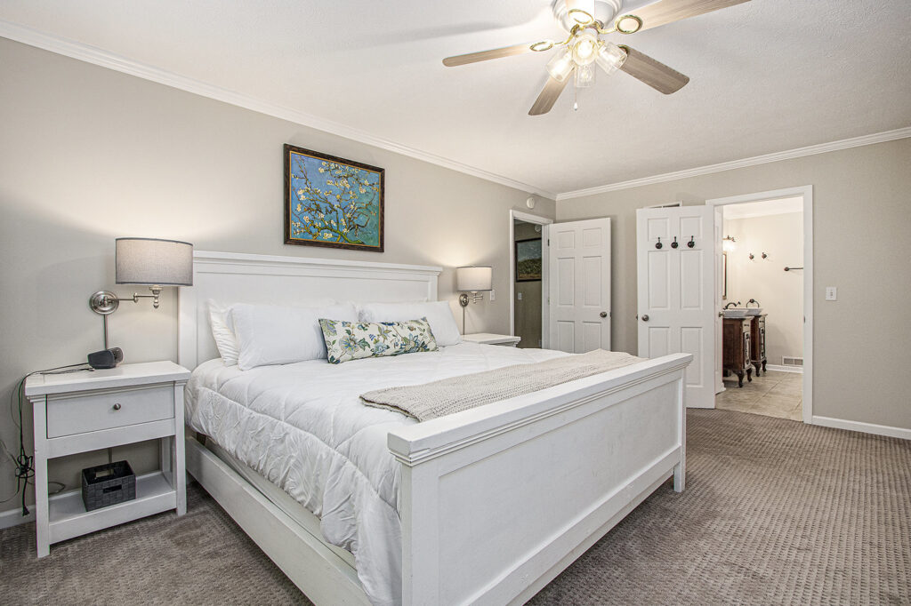 Cozy bedroom with white furniture and ceiling fan