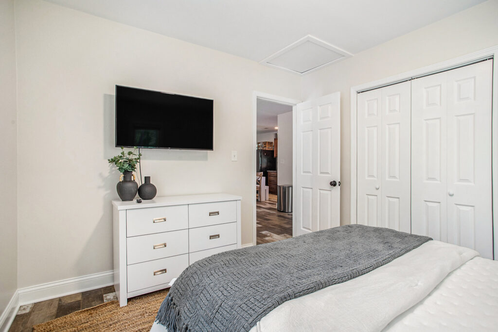Modern bedroom with TV and white dresser