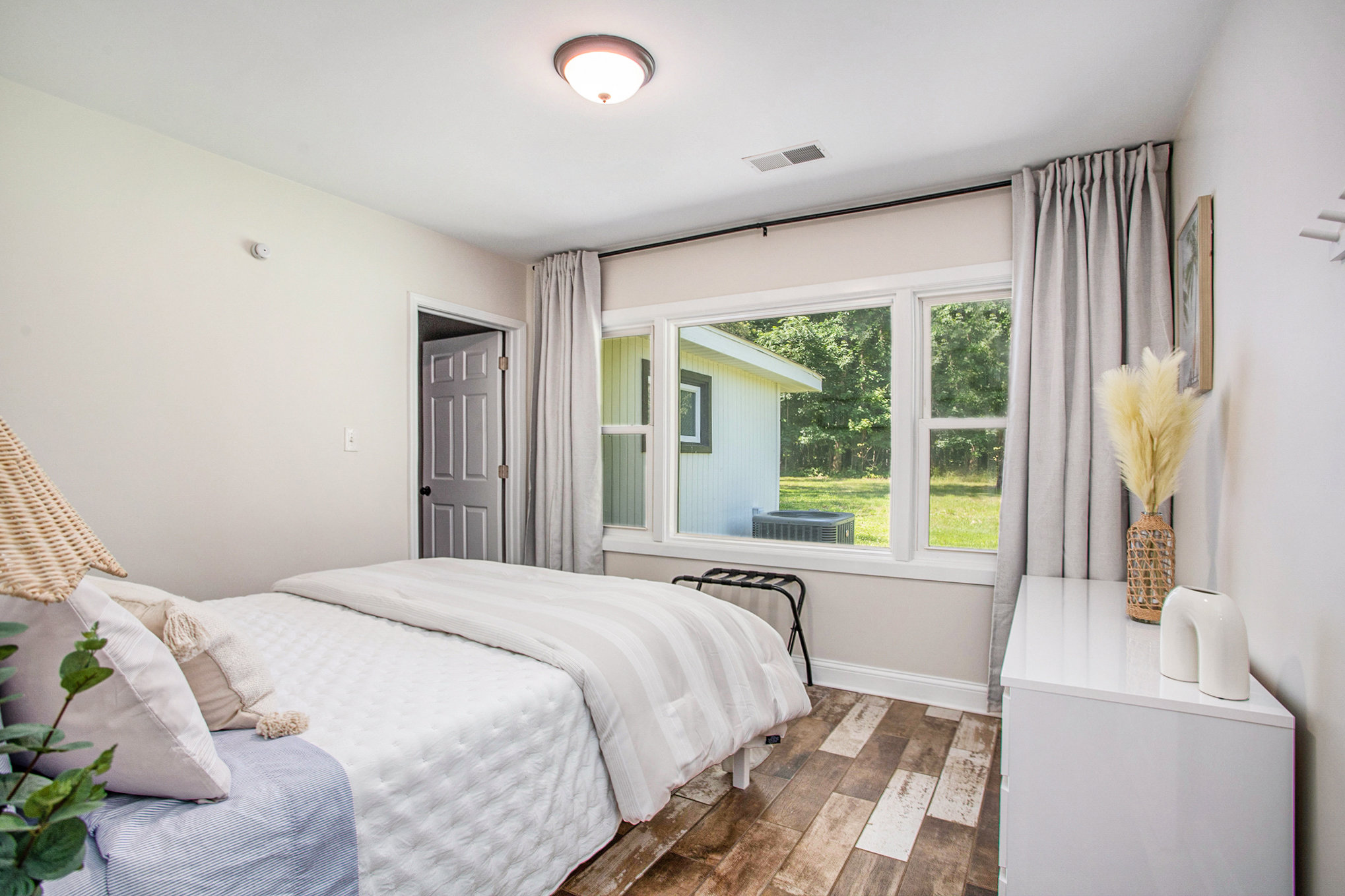 Bright bedroom with large window and cozy decor