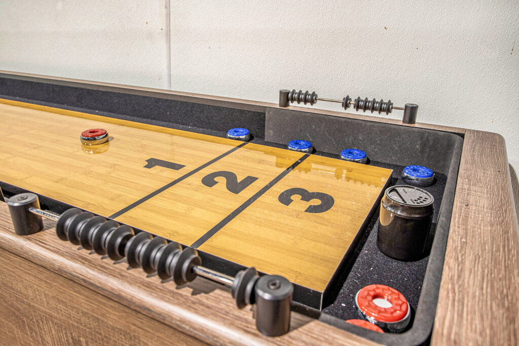 Wooden shuffleboard table with pucks and score beads