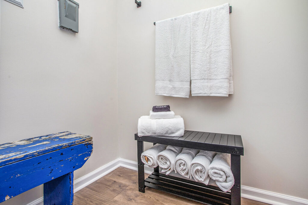 Bathroom towels neatly stacked on black shelf