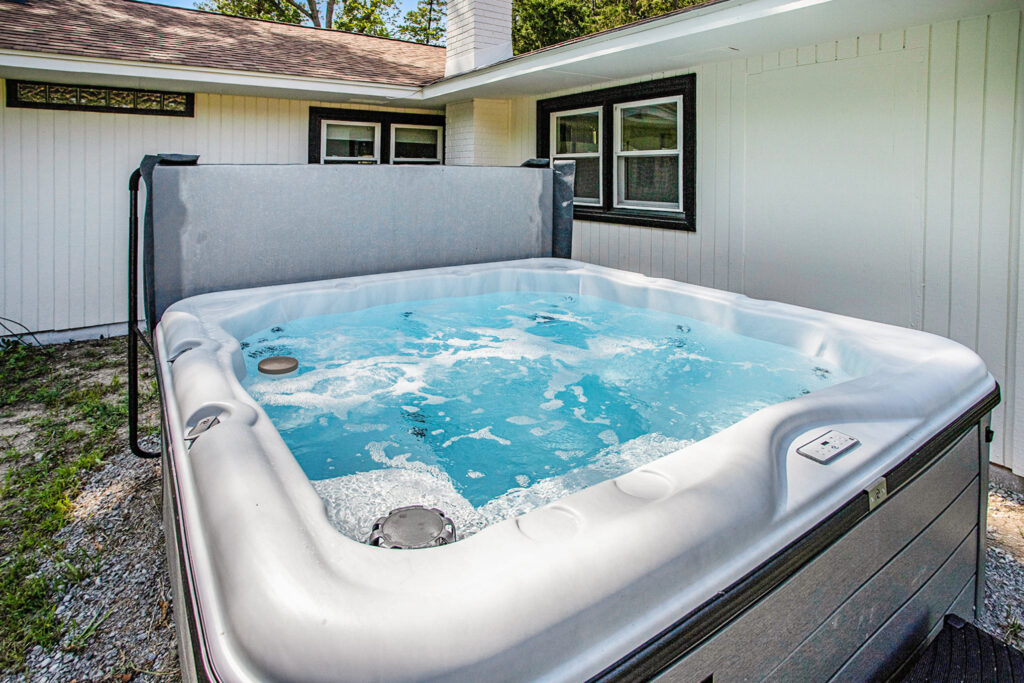 Outdoor hot tub beside white house