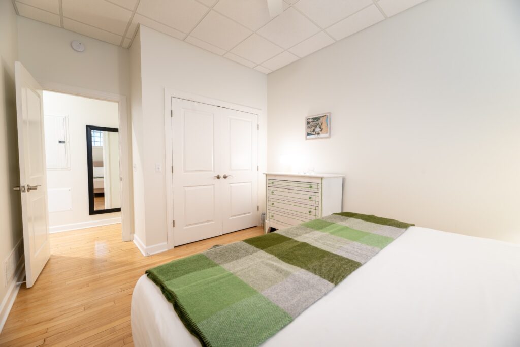 Bright bedroom with green plaid blanket