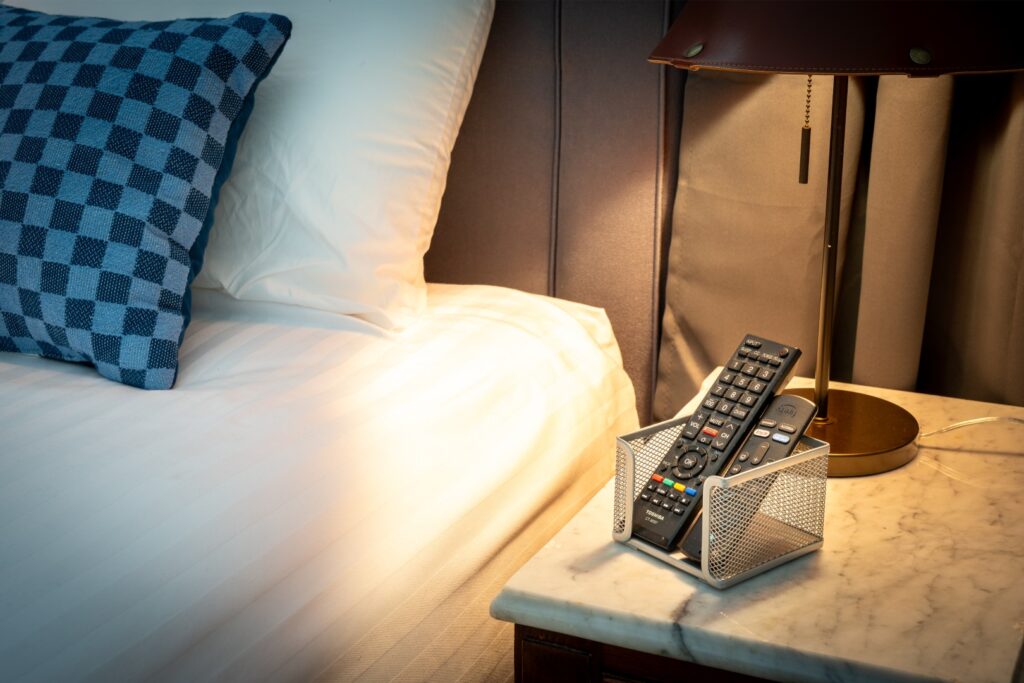 Remote controls on bedside table with lamp