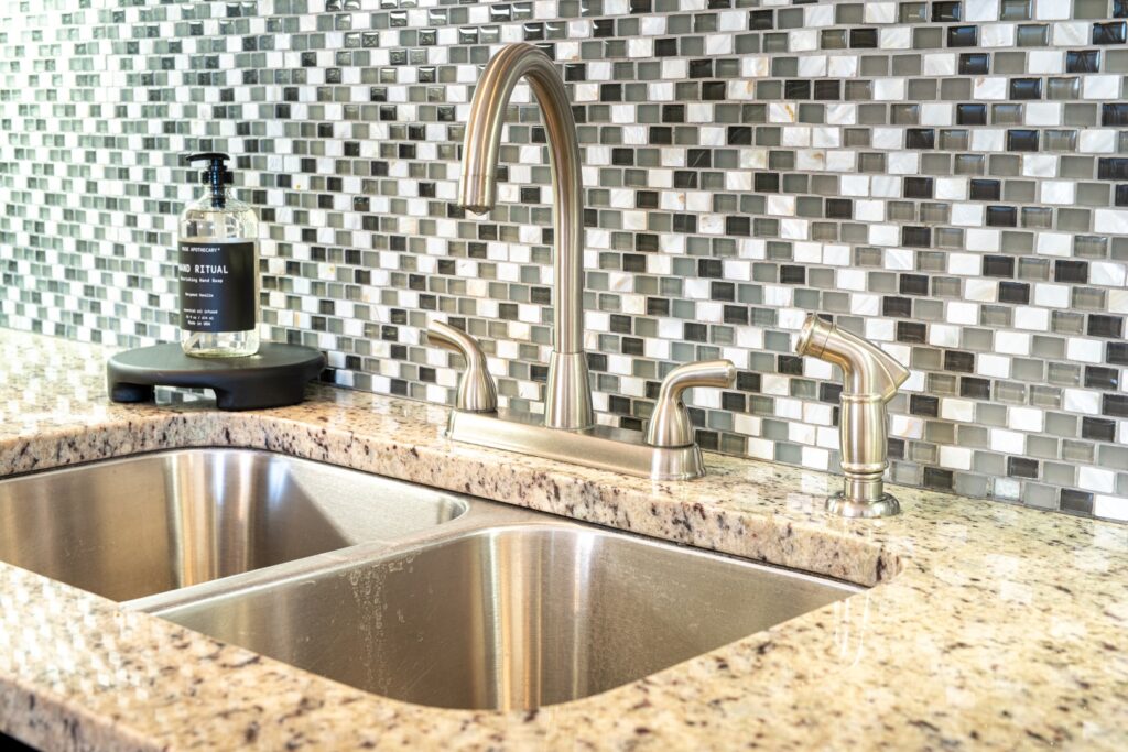 Modern kitchen sink with granite countertop and backsplash