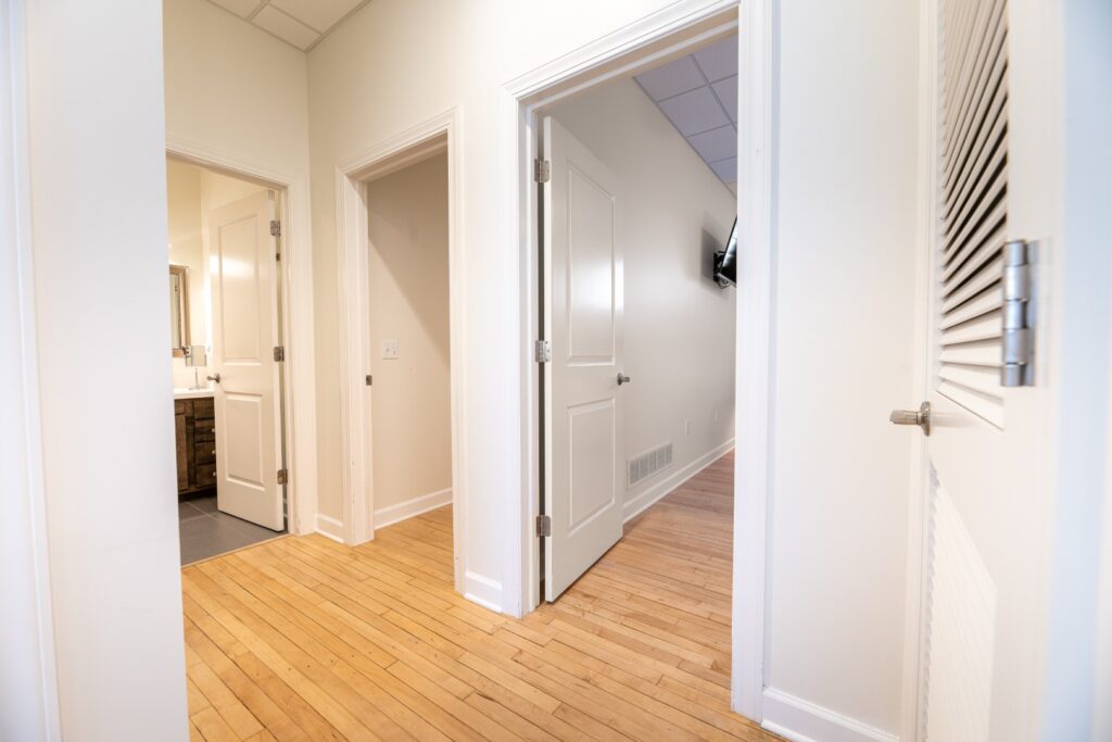 Bright hallway with wooden floor and open doors