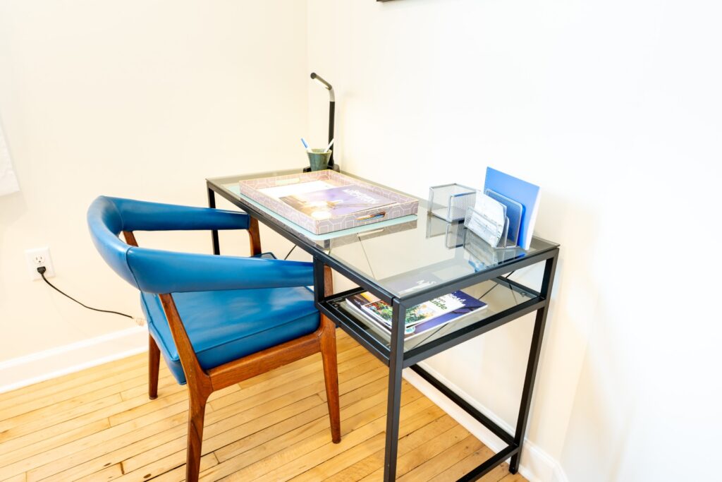 Modern glass desk with blue chair and lamp