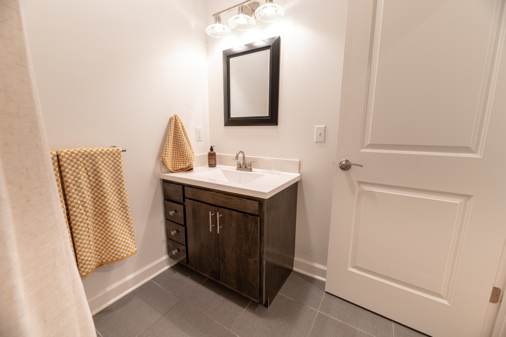 Modern bathroom with sink and yellow towels