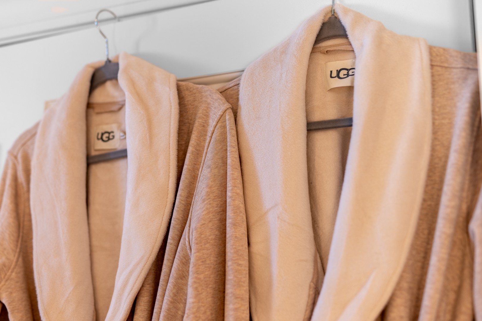 Beige UGG robes hanging on hooks