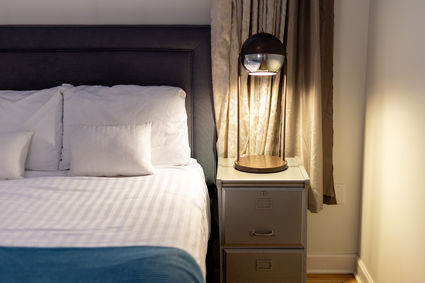 Bedroom nightstand with lamp beside bed