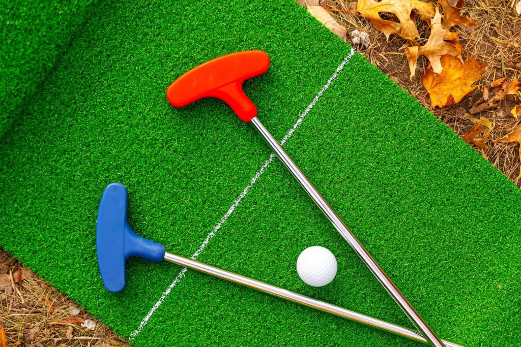Mini golf clubs and ball on green turf