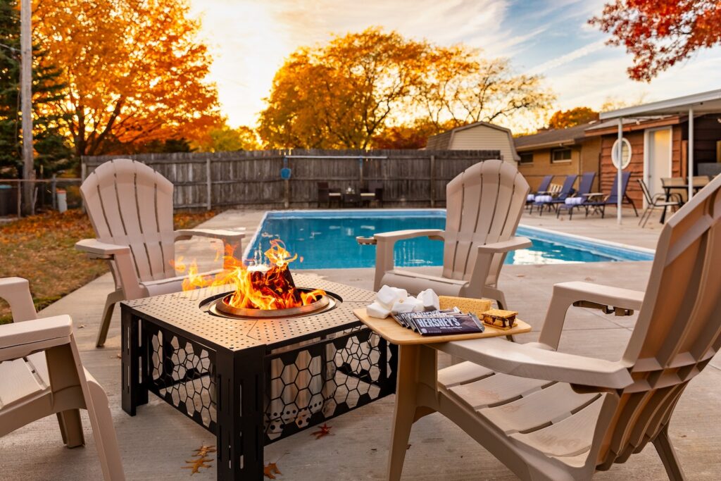 Backyard fire pit beside swimming pool in autumn