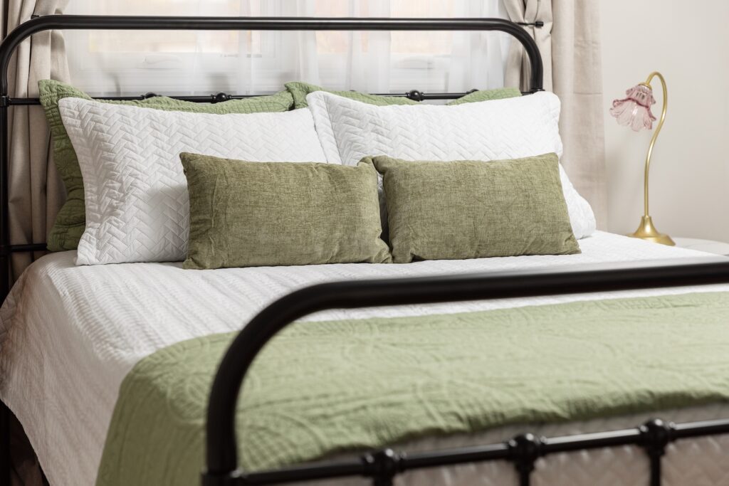Cozy bed with green and white bedding