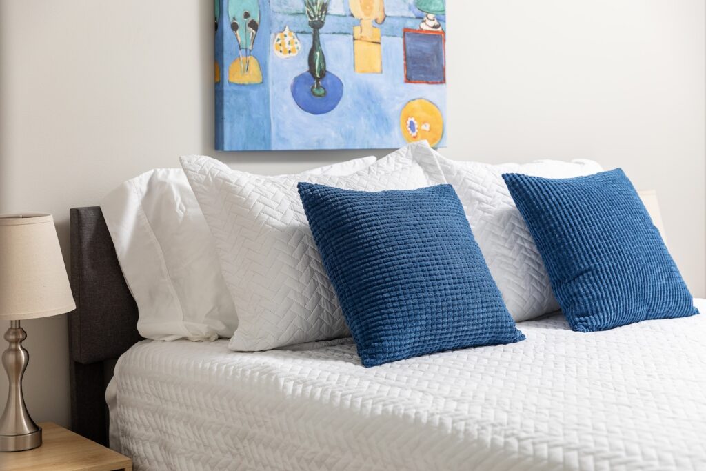 Modern bed with blue and white pillows