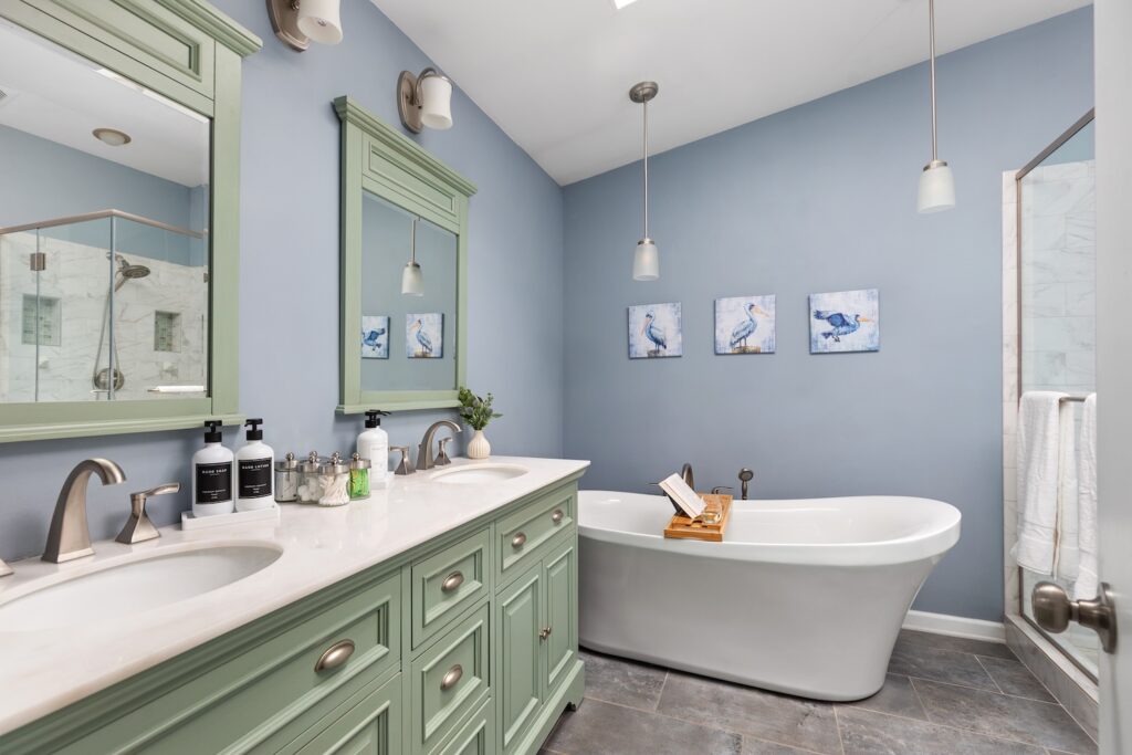 Modern blue bathroom with bathtub and double vanity