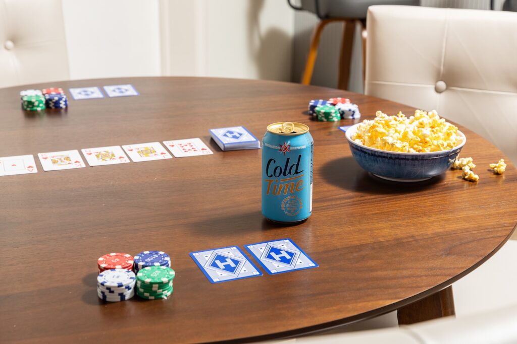 Poker game setup with chips, cards, popcorn, and drink